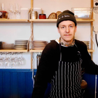 En-mans-krögaren som älskar kålrabbi och beskt och lagar mat på en kokplatta